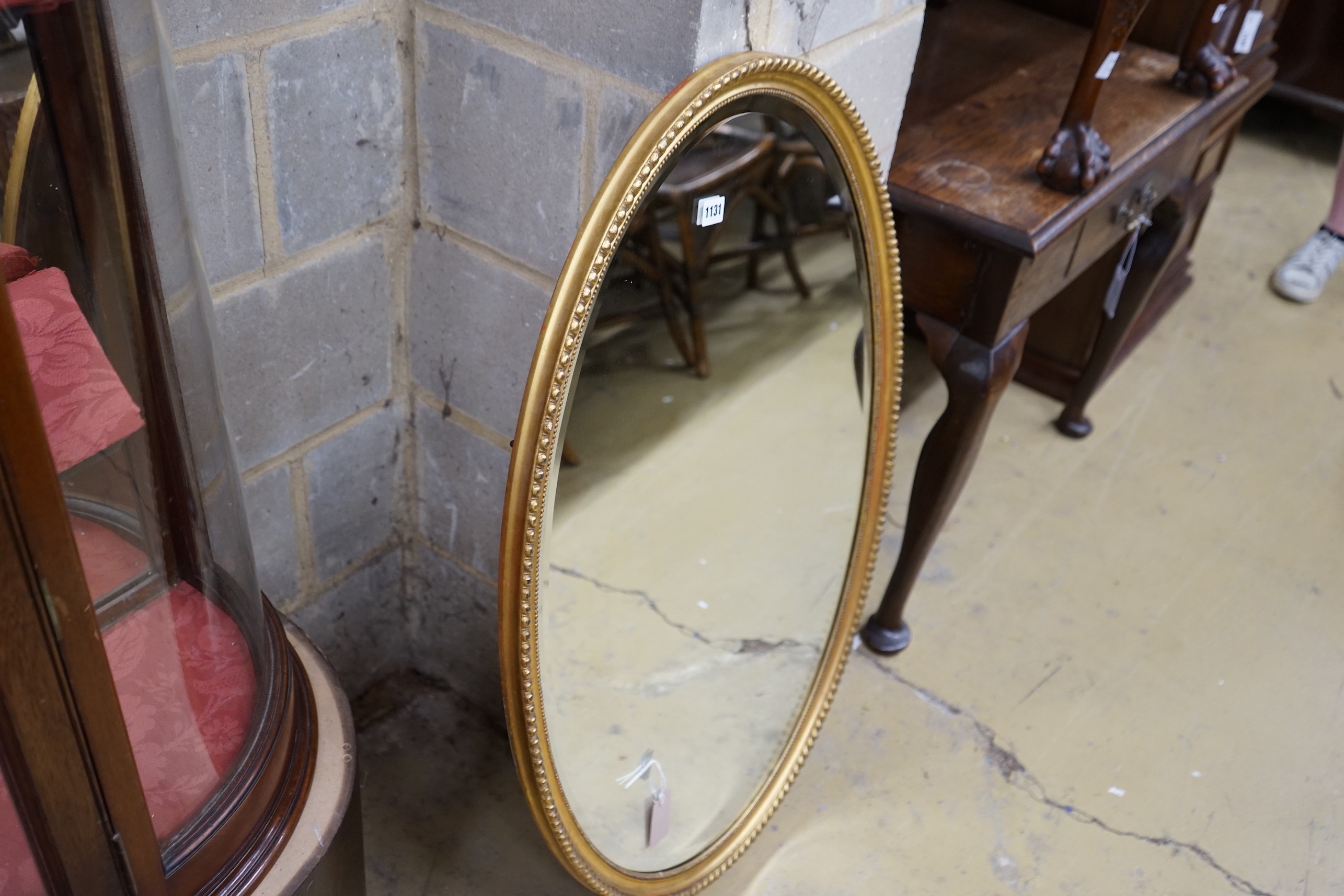 An oval gilt framed wall mirror, width 66cm, height 98cm